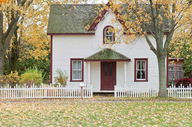 A house with a white picket fence in fall