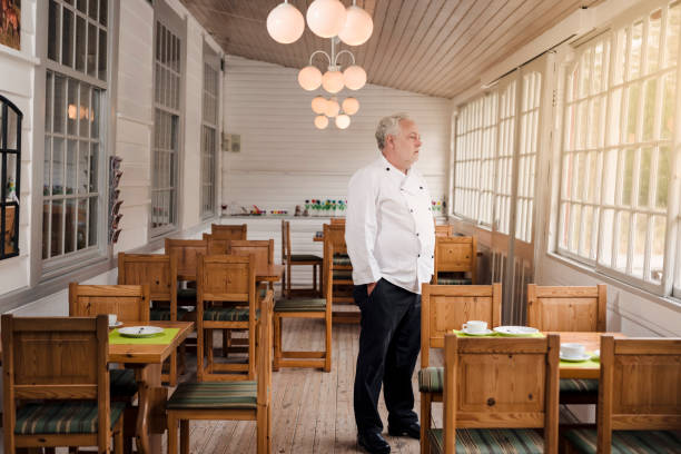 Chef standing in empty dining room.